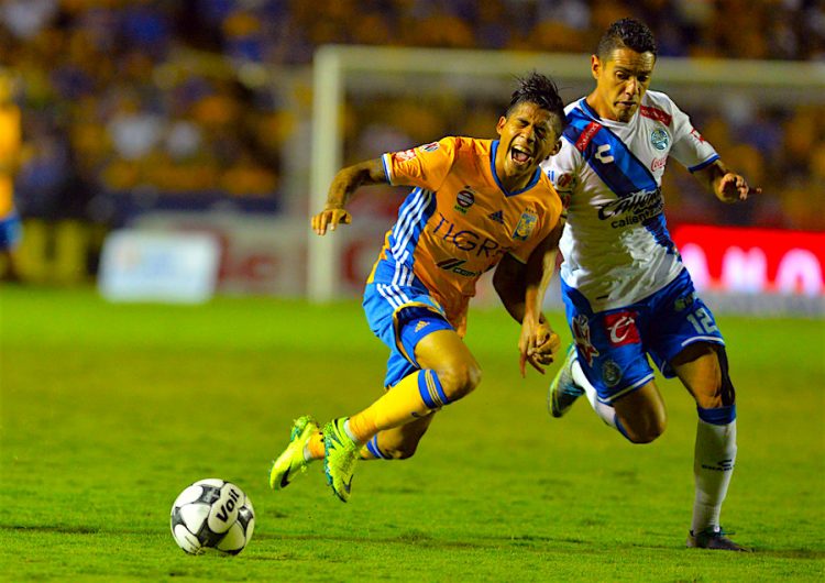 Javier Aquino (i) de Tigres disputa el balón con Oscar Rojas (d) de Puebla, 2016 celebrado en el estadio Universitario de la ciudad de Monterrey (México). EFE/Miguel Sierra