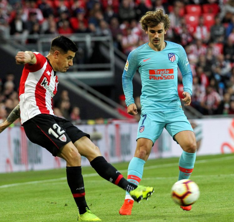 El defensa del Athletic, Yuri Berchiche (i), golpea el balón ante el delantero francés del Atlético de Madrid, Antoine Griezmann, durante el encuentro correspondiente a la jornada 28 de primera división que se disputo en el estadio de San Mamés, en Bilbao. EFE