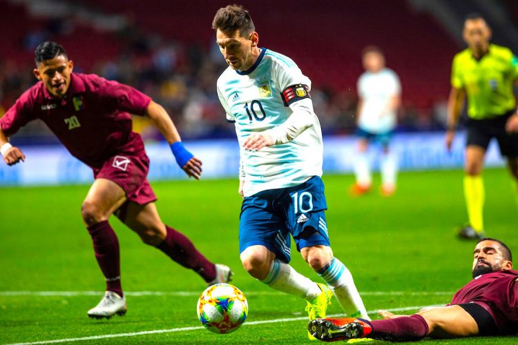 El delantero de la selección de Argentina, Leo Messi (i), se lleva el balón ante el centrocampista de Venezuela, Tomás Eduardo Rincón, durante el encuentro amistoso que disputo en el estadio Wanda Metropolitano, en Madrid. EFE