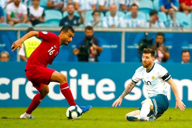Leo Messi (d) de Argentina disputa un balón ante Boualem Khoukhi (i) de Catar este domingo, durante el partido del Grupo B de la Copa América de Fútbol 2019, entre Catar y Argentina, en el Estadio Arena do Grêmio de Porto Alegre, (Brasil). EFE/ José Méndez
