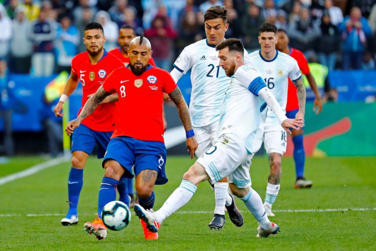 El jugador de Argentina Lionel Messi (i) disputa el balón con Arturo Vidal de Chile, durante el partido Argentina-Chile por el tercer puesto de la Copa América de Fútbol 2019, en el Estadio Arena Corinthians de São Paulo, Brasil, en fecha del 6 de julio de 2019. EFE/Sebastião Moreira