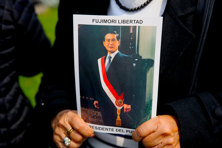 Una simpatizante del fallecido presidente de Perú Alberto sostiene un retrato de Fujimori en una fila para ingresar al velatorio este jueves, en el Ministerio de Cultura en Lima (Perú). El Gobierno peruano decretó desde este jueves un duelo nacional, que se prolongará por tres días, debido a la muerte del expresidente Alberto Fujimori, fallecido el miércoles a los 86 años. EFE/ Paolo Aguilar