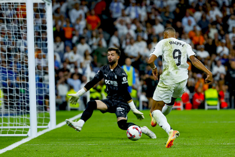 El delantero francés del Real Madrid, Kylian Mbappé (d), intenta superar al guardameta del Alavés, Antonio Sivera, durante el encuentro correspondiente a la séptima jornada de Laliga EA Sports que Real Madrid y Alavés disputaron en el estadio Santiago Bernabéu, en Madrid. EFE / Juanjo Martín.