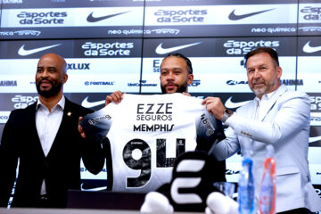 El futbolista neerlandés Memphis Depay (c), sostiene la camisa del Corinthians durante su presentación como nuevo jugador del club acompañado del presidente del Corinthians Augusto Melo (d) y el manager Fabio Soldado (i), durante una rueda de prensa este jueves en el estadio Neo Química Arena, sede del club Corinthians en Sao Paulo (Brasil). Depay fue recibido como una estrella en el aeropuerto internacional de Guarulhos, en São Paulo, por la afición del Corinthians, en un momento en que el equipo lucha por no descender a segunda división. EFE/ Sebastião Moreira