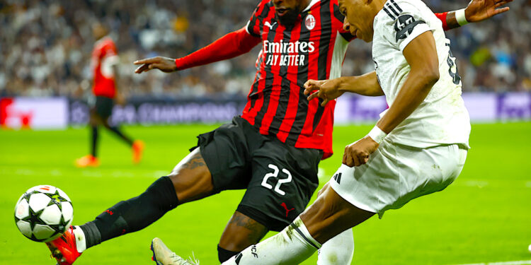 El delantero francés del Real Madrid, Kylian Mbappé (d), golpea el balón ante el defensa brasileño del Milan, Emerson, durante el encuentro correspondiente a la fase regular de la Liga de Campeones que disputaron el pasado martes Real Madrid y Milan en el estadio Santiago Bernabéu, en Madrid. EFE / Juanjo Martín.