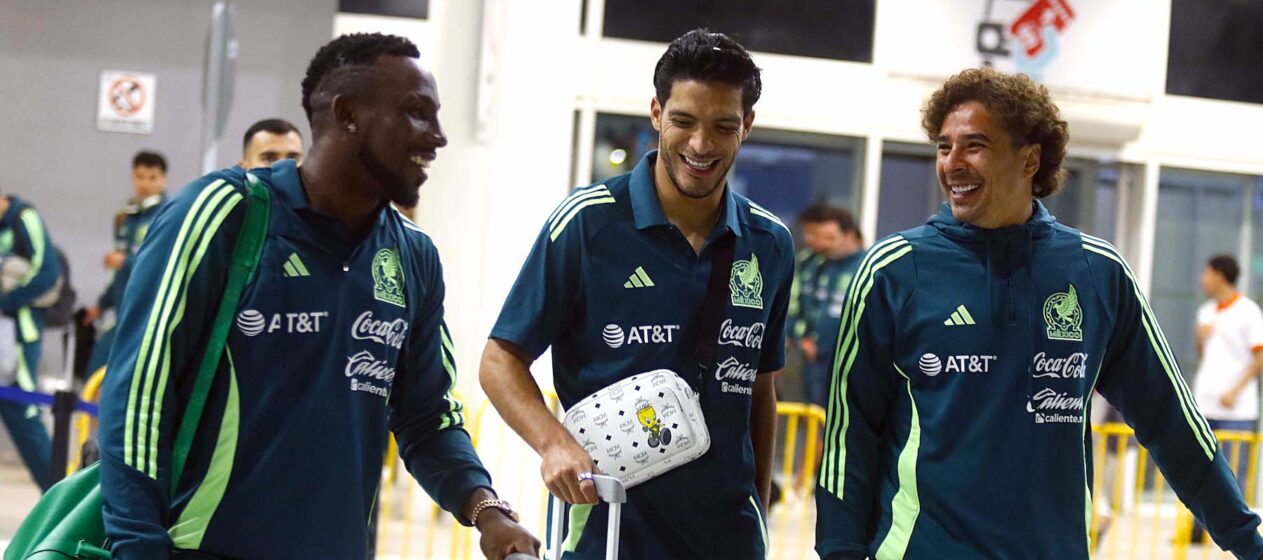 Julian Quiñones (i), Raúl Gímenez (c), y Guillermo Ochoa, jugadores de la selección mexicana de fútbol, hablan durante su llegada al aeropuerto Ramon Villeda Morales, este miércoles, en la ciudad de San Pedro Sula (Honduras). La selección mexicana enfrentará a Honduras en la ida de los cuartos de final de la Nations League de la Concacaf. EFE/ Jose Valle