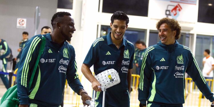 Julian Quiñones (i), Raúl Gímenez (c), y Guillermo Ochoa, jugadores de la selección mexicana de fútbol, hablan durante su llegada al aeropuerto Ramon Villeda Morales, este miércoles, en la ciudad de San Pedro Sula (Honduras). La selección mexicana enfrentará a Honduras en la ida de los cuartos de final de la Nations League de la Concacaf. EFE/ Jose Valle