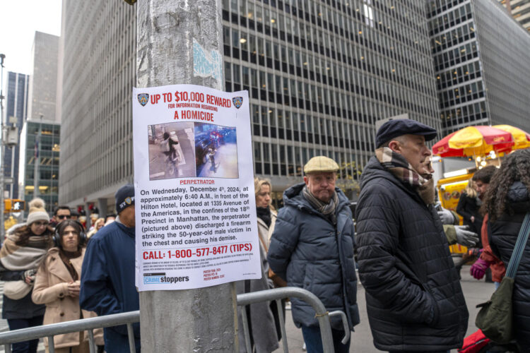 USA9603. NUEVA YORK (ESTADOS UNIDOS), 04/12/2024.- Personas caminan junto a un cartel de recompensa para quien ayude en la captura del asesino del director ejecutivo de la aseguradora UnitedHealthcare este miércoles en una calle de Manhattan, Nueva York (Estados Unidos). La Policía de Nueva York ofreció una recompensa por cualquier pista que lleve a capturar al hombre que esta mañana mató a disparos al director ejecutivo de la aseguradora UnitedHealthcare, Brian Thompson, en plena calle en Manhattan. EFE/ Ángel Colmenares