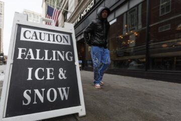 Un peatón pasa junto a un cartel que dice "Precaución: caída de hielo y nieve" en el distrito Downtown Crossing de Boston, Massachusetts, EE. UU., el 21 de enero de 2025. EFE/EPA/Cj Gunther