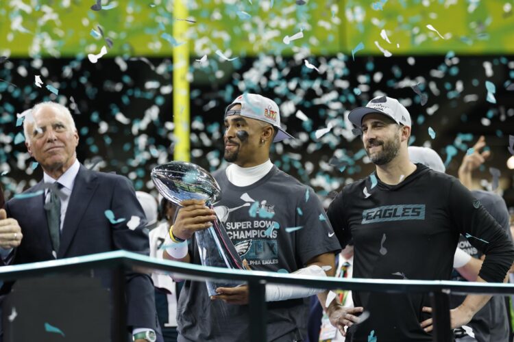 El mariscal de campo de los Philadelphia Eagles, Jalen Hurts, sostiene el trofeo Vince Lombardi junto al entrenador en jefe Nick Sirianni (d) y al propietario Jeffrey Lurie después de ganar el Super Bowl LIX contra los Kansas City Chiefs en el Caesars Superdome en Nueva Orleans, Luisiana (EE.UU.). EFE/ERIK S. LESSER