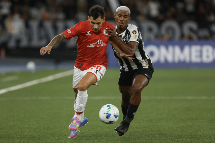 Cuiabano (d) de Botafogo disputa un balón con Eric Meza de Estudiantes de La Plata. EFE/ Antonio Lacerda